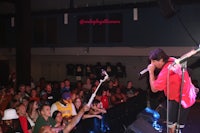a man on stage with a microphone in front of a crowd